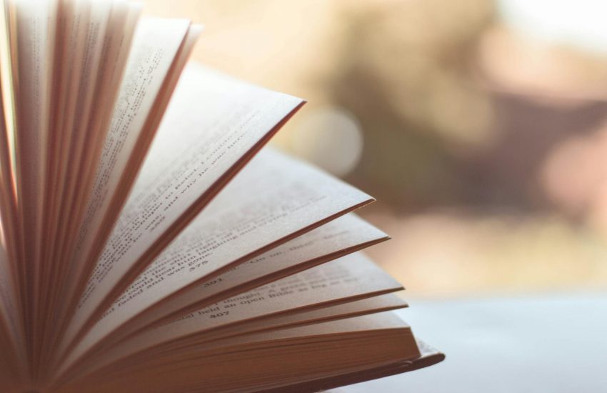 book opened on white surface selective focus photography