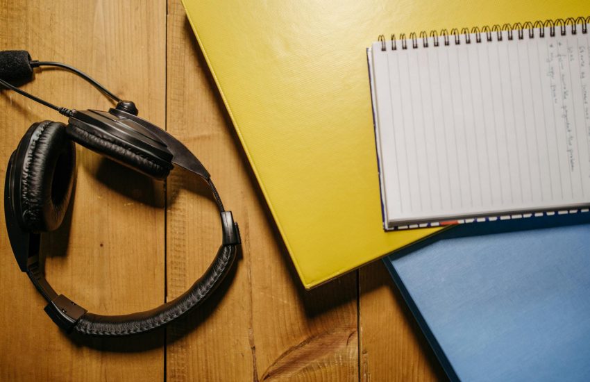 black headset near a notebook and folders